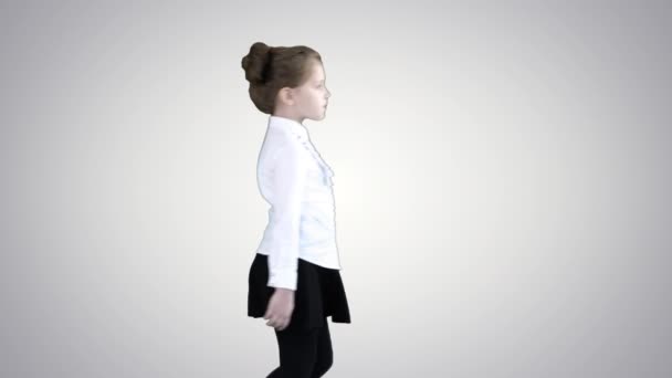 Bambina in uniforme scolastica passeggiando su sfondo gradiente . — Video Stock