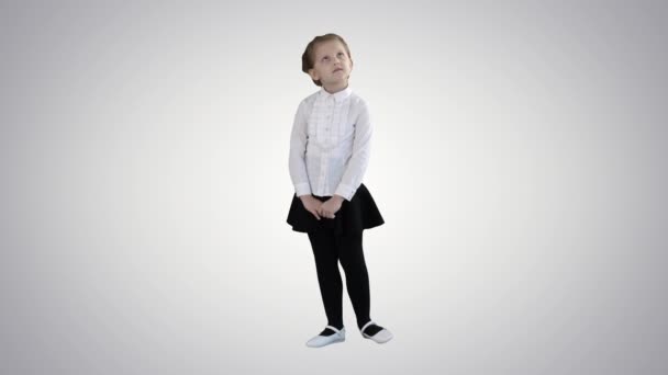 Χαριτωμένο κορίτσι προσχολικής ηλικίας στέκεται είναι ντροπαλός κοιτάζοντας γύρω και τη σκέψη σχετικά με κλίση φόντο. — Αρχείο Βίντεο