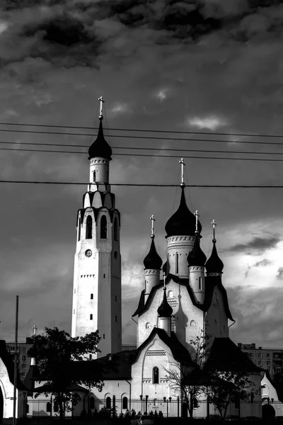 Bulutlu bir günde kuleleri olan kilise, siyah beyaz fotoğraf.