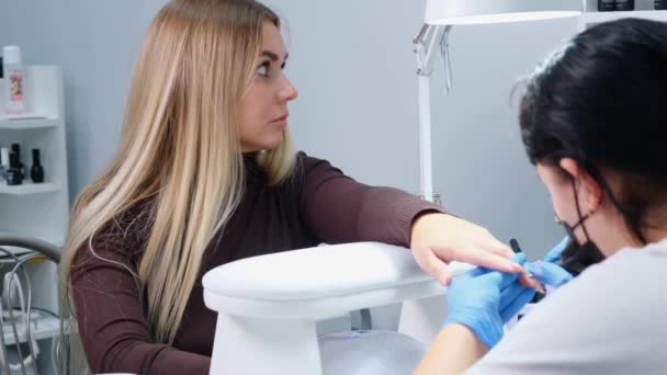 Mistrz stosuje lakier rysunek na paznokcie żel w salonie manicure — Wideo stockowe