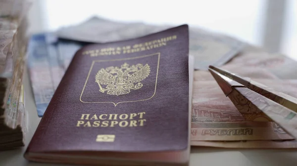 Em uma mesa branca há muito dinheiro, um passaporte e um pequeno avião feito de dinheiro. O conceito de descanso, preparação para férias, viagens . — Fotografia de Stock