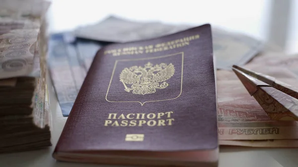 En una mesa blanca hay mucho dinero, un pasaporte y un pequeño avión hecho de dinero. El concepto de descanso, preparación para las vacaciones, viajes . — Foto de Stock