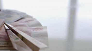 Beyaz bir masada çok para, pasaport ve paradan yapılmış küçük bir uçak var. Dinlenme kavramı, tatile hazırlık, seyahat.