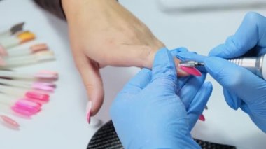 Manikür salonunda elektrikli çivi matkabı. Güzellik salonunda hırdavatçı manikürü. Kadın manikürcü müşterilerin tırnaklarından eski jeli alıyor. Vakum ızgarası. Güzellik salonunda çivi manikürü..