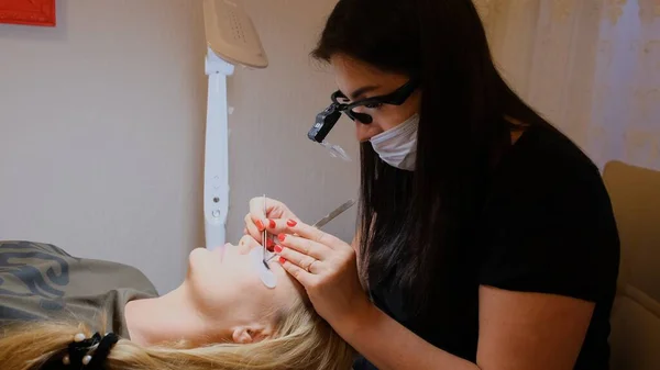 Procédure d'extension des cils. Le maître fait pousser de longs cils. Femme avec cils allongés — Photo