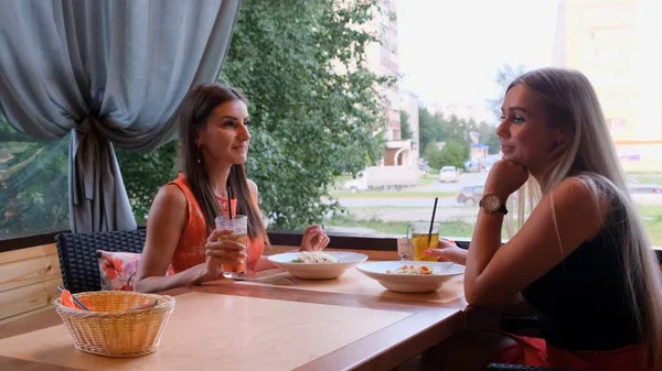 Dois amigos num café-bar bebem cocktails num terraço aberto . — Fotografia de Stock