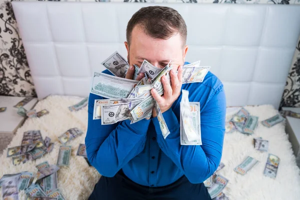 Male holds in his hands a lot of money. and kisses them. A man enjoys a lot of cash dollars. Tremendous wealth concept. — Stock Photo, Image