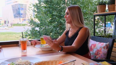 telefonda sohbet güzel sarışın kadın, kadın bir toplantı bekliyor, sokakta bir kafede oturan.