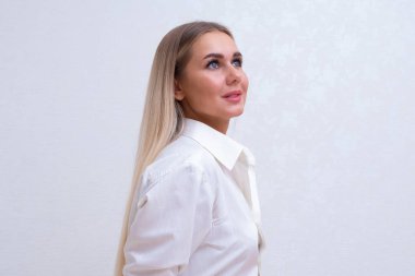 Beyaz gömlekli düşünceli bir sarışının portresi..