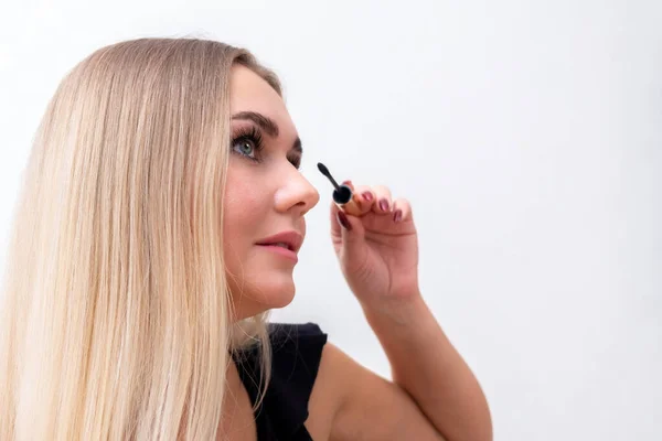 Ciglia make-up girl, giovane bella bionda dipinge ciglia, applica mascara a casa al mattino . — Foto Stock