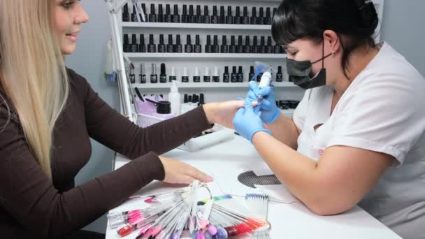 Nizjnevartovsk, Rusland - 12 augustus 2019: Elektrische Nagelboor in Manicure Salon. Hardware manicure in een schoonheidssalon. Vrouwelijke manicure verwijdert oude gel van cliënten nagels. Zuiggrill. Nagelmanicure — Stockvideo