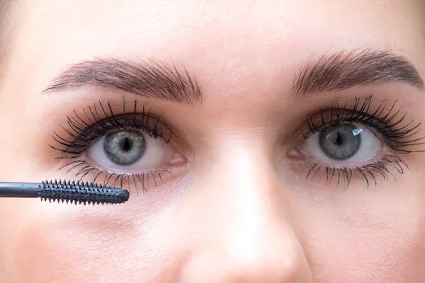 Weibliche Augen mit Mascara-Pinsel. weibliche Augen mit langen Wimpern und einer Mascara-Bürste. — Stockfoto