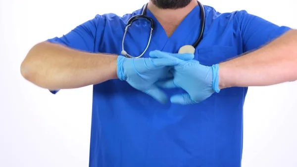 Orvos egy férfi kék egyenruhában húzza kék kesztyű a kezét a fehér háttér — Stock Fotó