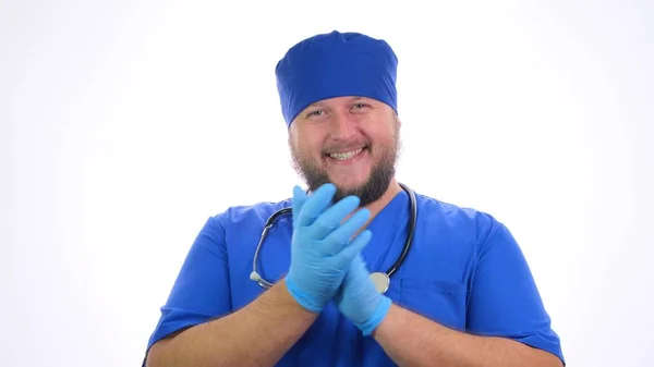 Barbu souriant travailleur médical masculin en vêtements bleus applaudit ses mains . — Photo