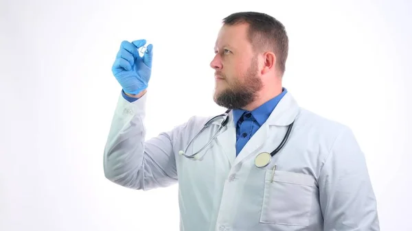 Scientifique travaille dans un laboratoire. Jeune médecin sérieux dans des gants tient une fiole médicale avant d'examiner et de traiter un patient dans un hôpital — Photo