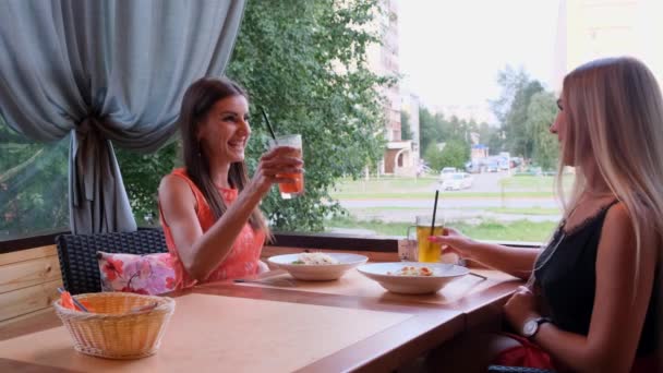 Dois amigos num café-bar bebem cocktails num terraço aberto . — Vídeo de Stock