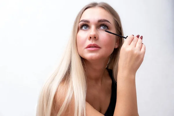 Headshot de femme avec un maquillage lumineux appliquant mascara sur les cils . — Photo