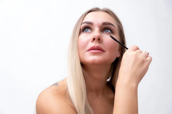 Occhi femminili con ciglia lunghe estreme e una spazzola di mascara. Trucco, cosmetici, bellezza . — Foto Stock