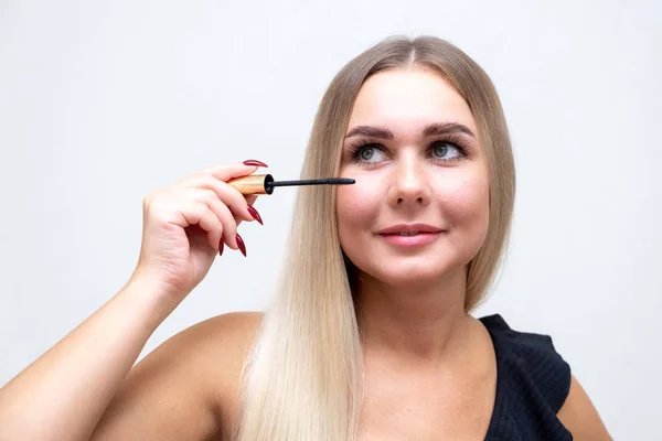 Makyaj. Makyaj malzemesi. Mascara sürüyorum. Uzun kirpikleri var. Göz maskarası süren bir kadın.. — Stok fotoğraf