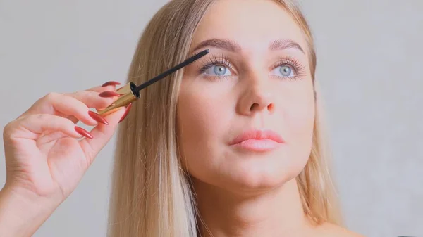 Makeup. Make-Up. Applying Mascara. Long Eyelashes. Woman applying eye mascara to her eyelashes.