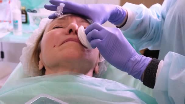 Frau mittleren Alters 50 bekommt von einem Arzt eine Spritze ins Gesicht gespritzt. kosmetischer Eingriff. Nahaufnahme — Stockvideo