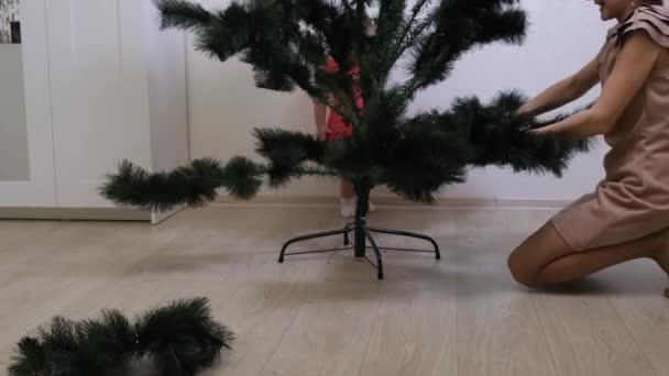 Felice mamma e figlia raccolgono albero di Natale a casa. Natale e Capodanno preparazione — Video Stock