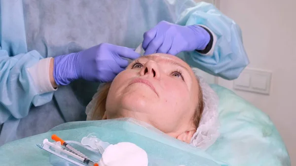 Kvinna får kosmetisk injektion av botox, närbild. En kvinna i skönhetssalong. plastikkirurgi klinik — Stockfoto
