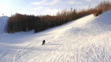 Güneşli bir kış gününde snowboardcu dağın tepesinden kayar. Gerçek manzara. Snowboard konsepti.
