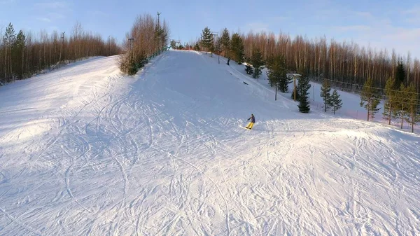 Πάνω άποψη ενός snowboarder ολίσθηση κάτω από την κορυφή ενός βουνού σε μια ηλιόλουστη μέρα του χειμώνα. Η έννοια του snowboarding. — Φωτογραφία Αρχείου