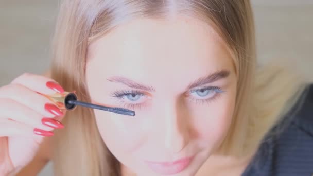 Das kaukasische Model bemalt Wimpern mit Wimperntusche. Make-up Frau — Stockvideo