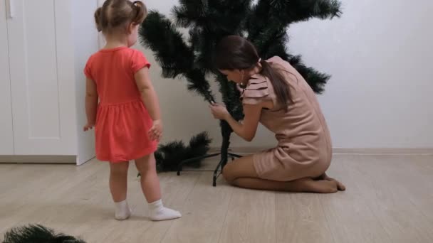 Happy mom and daughter collect christmas tree at home. Christmas and New Year preparation — Stock Video