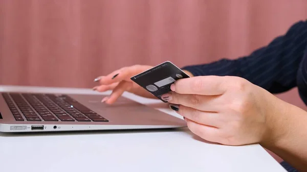 Manos femeninas hacer una compra en Internet utilizando un ordenador portátil, pago con tarjeta, primer plano . —  Fotos de Stock