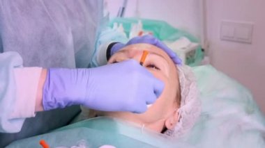 Kadın kozmetik iğnesi yaptırıyor, yakın çekim. Güzellik salonundaki kadın. Plastik cerrahi kliniği