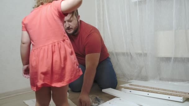 Papá colecciona muebles blancos para el hogar. Hija ayuda a papá a recoger muebles . — Vídeos de Stock