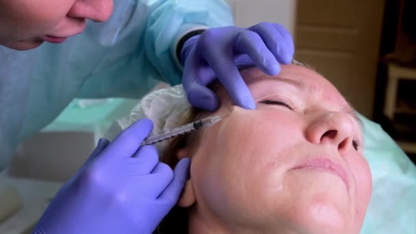 Женщине делают косметическую инъекцию крупным планом. Женщина в салоне красоты. клиника пластической хирургии — стоковое видео