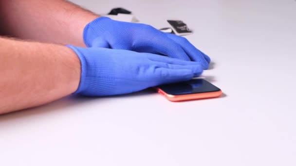 Maschio sostituisce una protezione dello schermo in vetro temperato rotto per uno smartphone. Un uomo prepara uno smartphone per sostituire il vetro. Smartphone concetto di riparazione — Video Stock