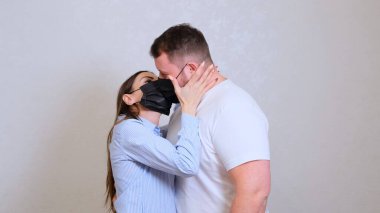 Kadın ve erkek koruyucu maskeli öpüşürler. Hijyen konsepti. Mikrop ve bakterilerin yayılmasını önler ve taç virüsü bulaşmasını önler.