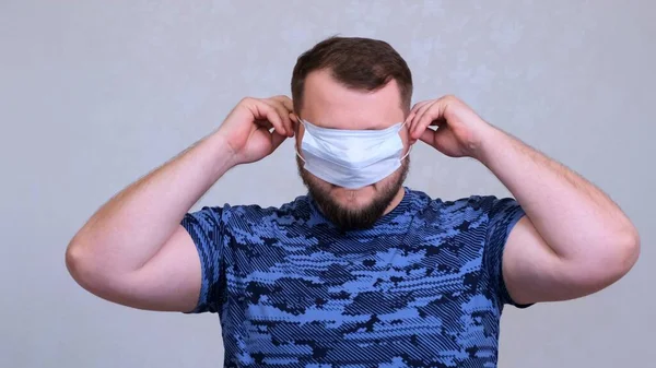 Muž si nasadí ochrannou masku. Skrývá si oči. koncepce zabránit šíření bakterií a bakterií a vyhnout se infekci korunním virem — Stock fotografie