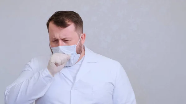 Lékař kašle v ochranné masce infikované virem nebo koronavirem. — Stock fotografie