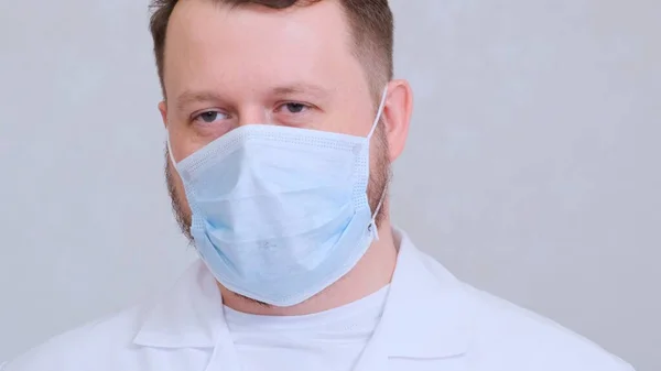 Triste et contrarié Homme dans un masque de protection et une chemise blanche regarde la caméra, gros plan. Concept d'hygiène. prévenir la propagation des germes et des bactéries et éviter l'infection par le virus de la couronne. espace de copie — Photo