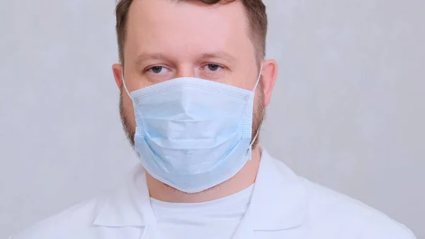 Egy férfi védő maszkban és fehér ingben a kamerába néz, közelről. Higiéniai koncepció. megakadályozza a baktériumok és baktériumok terjedését, és elkerüli a koronavírussal való fertőződést. másolás helye — Stock Fotó