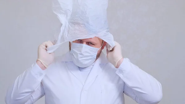 Bearded man in a bag on his head. Fear of infection. Coronavirus COVID-19 Pandemic, home self-isolation and quarantine. — Stock Photo, Image