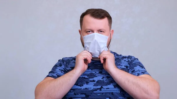 O homem põe uma máscara protectora. Conceito de higiene. prevenir a propagação de germes e bactérias e evitar a infecção com o vírus da coroa — Fotografia de Stock