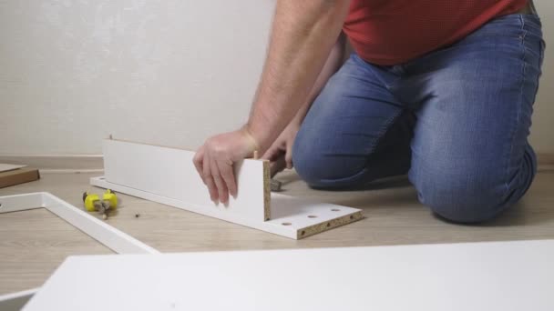 Dad man collects white home furniture. Daughter helps dad to collect furniture. close-up — 비디오