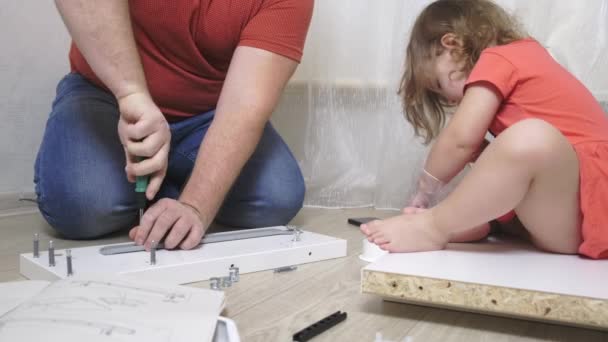 Hija con papá montar muebles blancos juntos. De cerca. . — Vídeo de stock