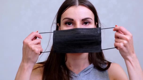 Female patient puts on a black protective mask. Hygiene concept. prevent the spread of germs and bacteria and avoid infection with the crown virus — Stock Video