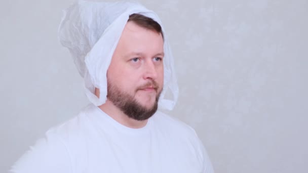 Bearded man in a bag on his head. Fear of infection. Coronavirus COVID-19 Pandemic, home self-isolation and quarantine. — Stock Footage Bearded man in a bag on his head. Fear of infection. Coronavirus COVID-19 Pandemic, home self-isolation and quarantine. Stock Footage