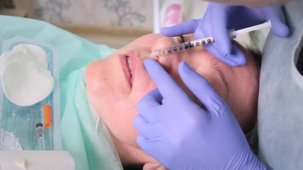 Le cosmétologue effectue une procédure pour augmenter les lèvres d'une femme dans un salon de beauté. soin de la peau. Injections cosmétiques . — Video