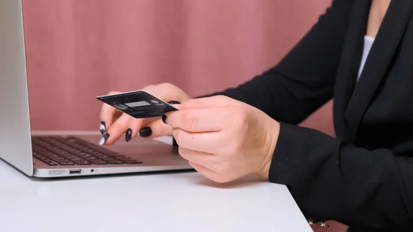 Manos femeninas hacer una compra en Internet utilizando un ordenador portátil, pago con tarjeta, primer plano . —  Fotos de Stock