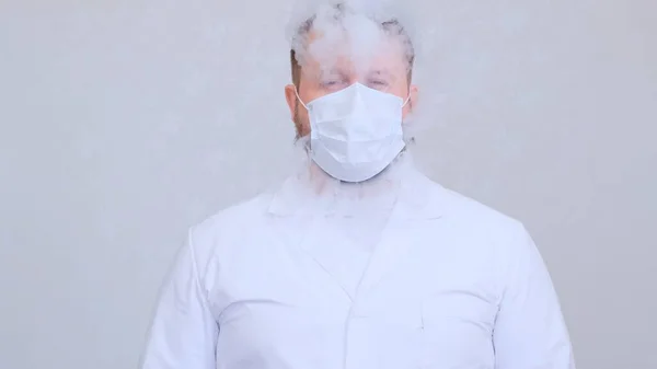身穿白衣的男性通过防护口罩吸烟。对病毒、头孢病毒、肺病的防护 — 图库照片